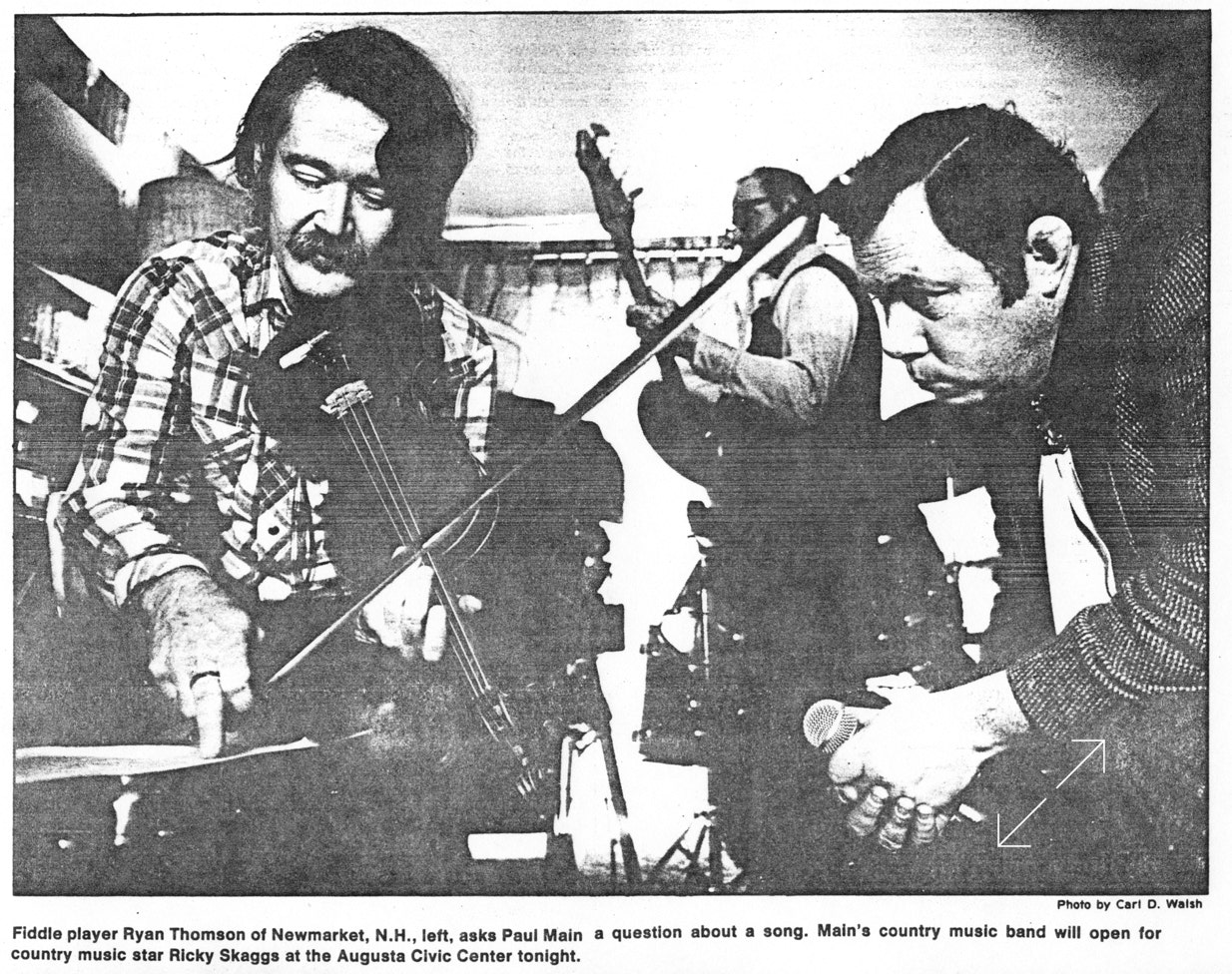 Fiddler Ryan Thomson discusses repertoire with Paul Main while preparing to open for Ricky Skaggs at the Augusta Civic Center.